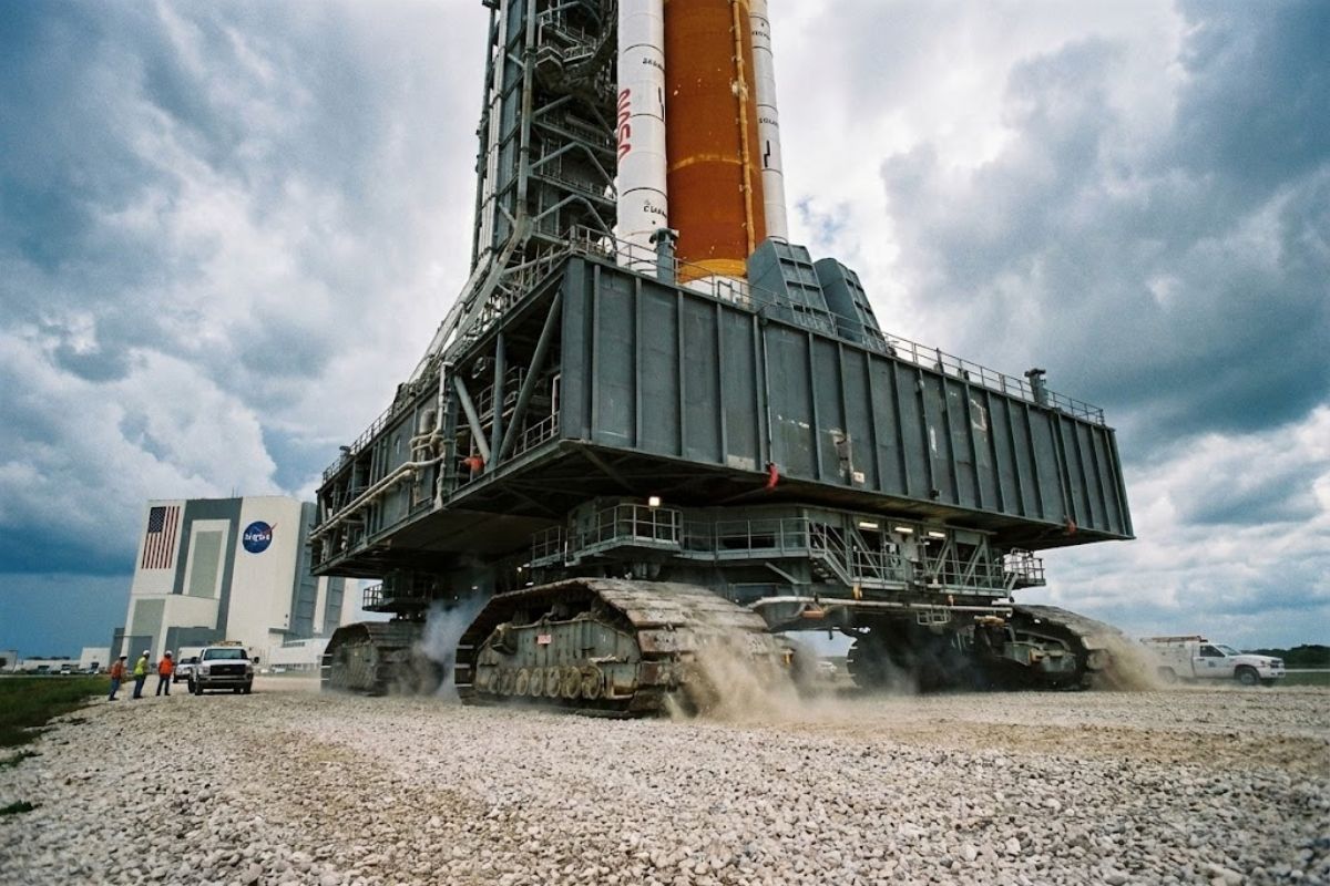 caminhão gigante da NASA Crawler Transporter leva Saturn V e Artemis no Kennedy Space Center com diesel extremo e precisão no caminho até a plataforma.